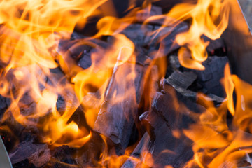 Burning coals in mangal with bright flame