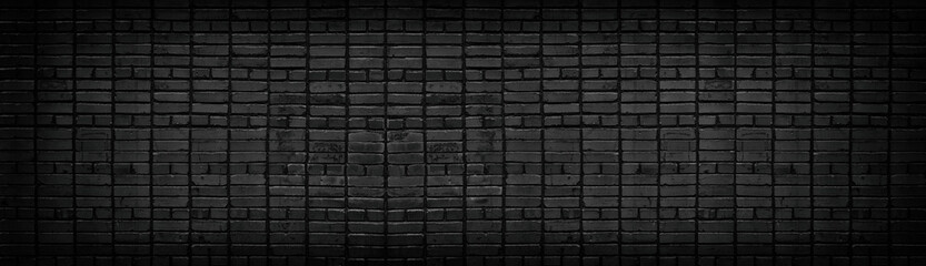 Wide old black brick wall texture. Dark gray panoramic brickwork background