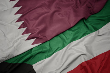 waving colorful flag of kuwait and national flag of qatar.