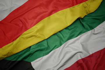 waving colorful flag of kuwait and national flag of south ossetia.