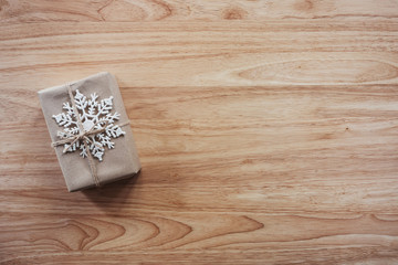 Above brown gift and christmas decoration on wooden background