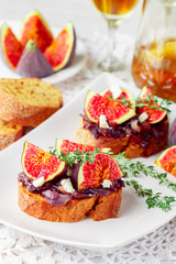 Grain baguette sandwiches with figs, feta cheese, red onion marmalade and thyme . Delicious snack for gourmands. Selective focus
