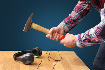 man in a plaid shirt hammering on headphones, a bad sound concept, close-up, copy space, isolate