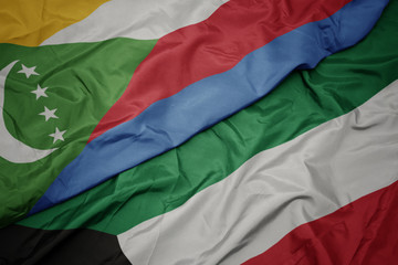 waving colorful flag of kuwait and national flag of comoros.