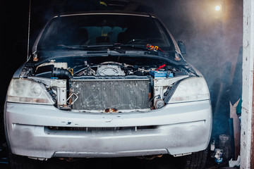 Fototapeta na wymiar SUV engine repair, car in smoke in the garage