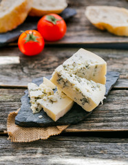 Blue cheese with cherry tomatoes on wooden rustic table