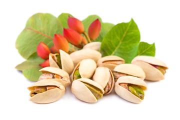 Red pistachio nuts with leaves on white background