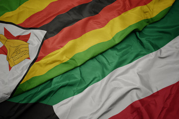 waving colorful flag of kuwait and national flag of zimbabwe.