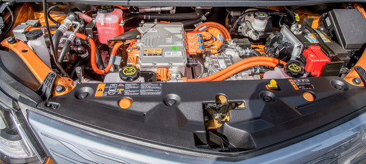 under the hood of an orange electric car, technology of the future