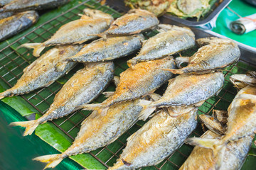 Fried mackerel on the grille for sale in the market.
