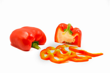 Half cut and sliced fresh red sweet ripe bell pepper isolated on white background.
