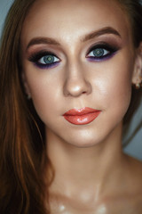 Fototapeta premium Portrait of a young woman with beautiful evening make-up on a dark background