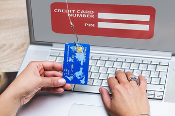 Credit card phishing. Phishing scam with credit card in fishing hook. Woman typing her credit card...