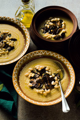 mushroom soup with Italian cannellini beans and fennel in clay pots on a table. Autumn healthy vegan food. top shot