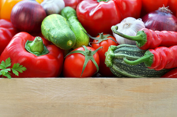 Harvest fresh vegetables in a wooden box with copy space below. The concept of healthy food.