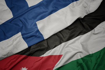 waving colorful flag of jordan and national flag of finland.