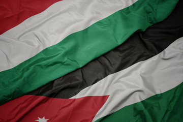 waving colorful flag of jordan and national flag of hungary.
