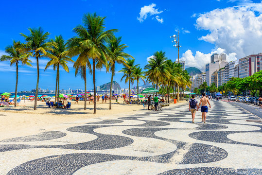 View of Copacabana beach and Leme beach with palms and mosaic of sidewalk in Rio de Janeiro, Brazil