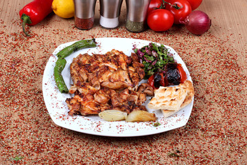 Roast chicken with green pepperoni and salad with fresh vegetables on a wooden table topped with spicy high-angle spices