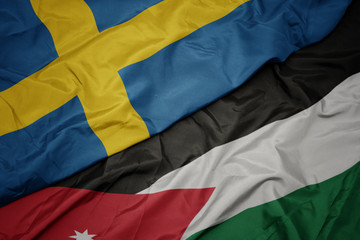 waving colorful flag of jordan and national flag of sweden.