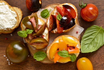 Bruschetta with soft cheese, tomatoes and basil,  top view 