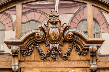 beautiful wooden bas-relief on the door against the background of the facade of the building