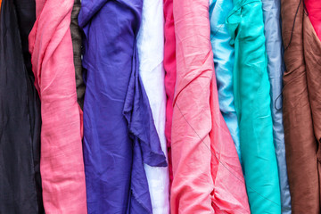Bolts of different colour linen fabric on display.