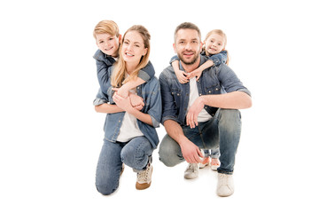 Fototapeta premium happy family in jeans embracing and smiling isolated on white