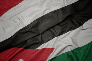 waving colorful flag of jordan and national flag of yemen.