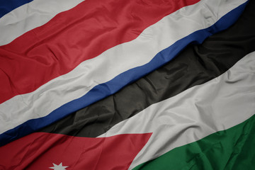 waving colorful flag of jordan and national flag of costa rica.