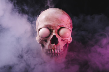 Cranium with spooky eyeballs in smoke