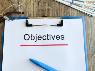 Paper with text objective on wood table.