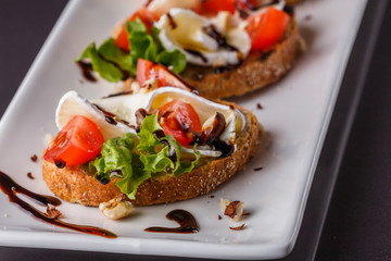 Bruschetta with tomatoes, lettuce, camambert, balsamic vinegar