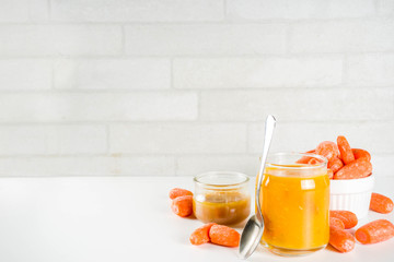 Homemade carrot jam with fresh baby carrots, copy space