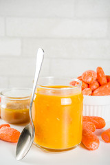 Homemade carrot jam with fresh baby carrots, copy space