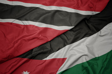 waving colorful flag of jordan and national flag of trinidad and tobago.