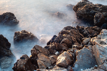 Beautiful stones, rocks and sea in a mystical haze at sunset. Long exposure. cool light landscape. Turkey. Aegean sea shore.