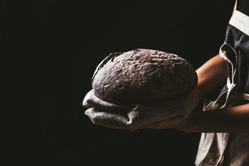 rustic bread in baker hand, healthy food