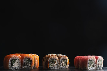 Traditional Japanese food - sushi, rolls and sauce on a black background