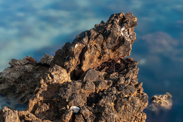 Sharp stones and rocks in the turquoise, blue sea. Beautiful seascape. Aegean coast in Turkey at sunrise. Bodrum.