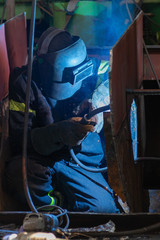 Welder working on ship repairing yard
