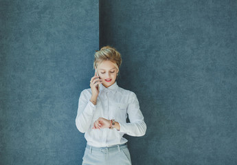 busy business woman talking on the phone and looks at the watch