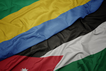 waving colorful flag of jordan and national flag of gabon.