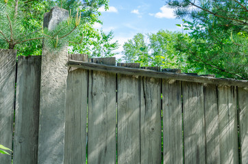 Naklejka premium Broken fence.A rickety old Board fence in the woods.