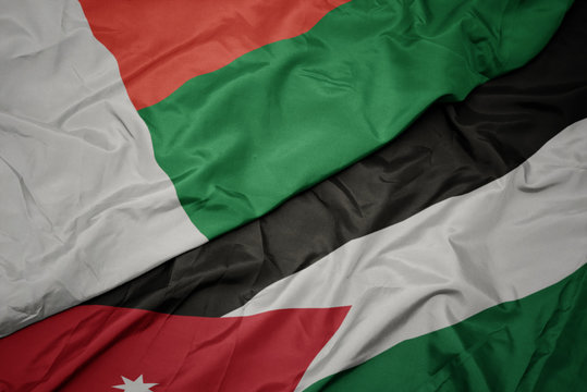 waving colorful flag of jordan and national flag of madagascar.