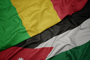 waving colorful flag of jordan and national flag of mali.
