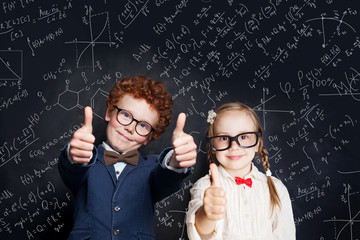 Smart children student having fun on blackboard background with science and maths formulas