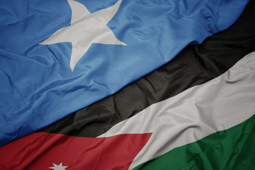 waving colorful flag of jordan and national flag of somalia.