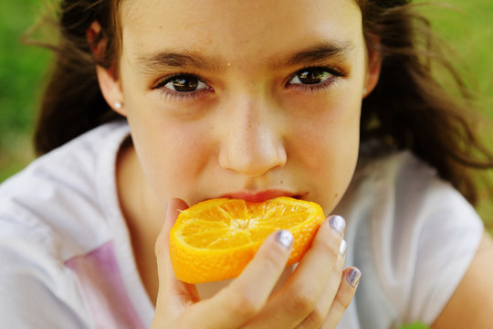 Happy 12 Year Old Girl Smiling And Holding Orange Slices