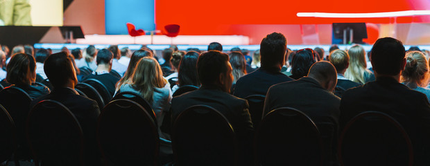 Banner cover page of Rear view of Audience listening Speakers on the stage in the conference hall or seminar meeting, business and education about investment concept